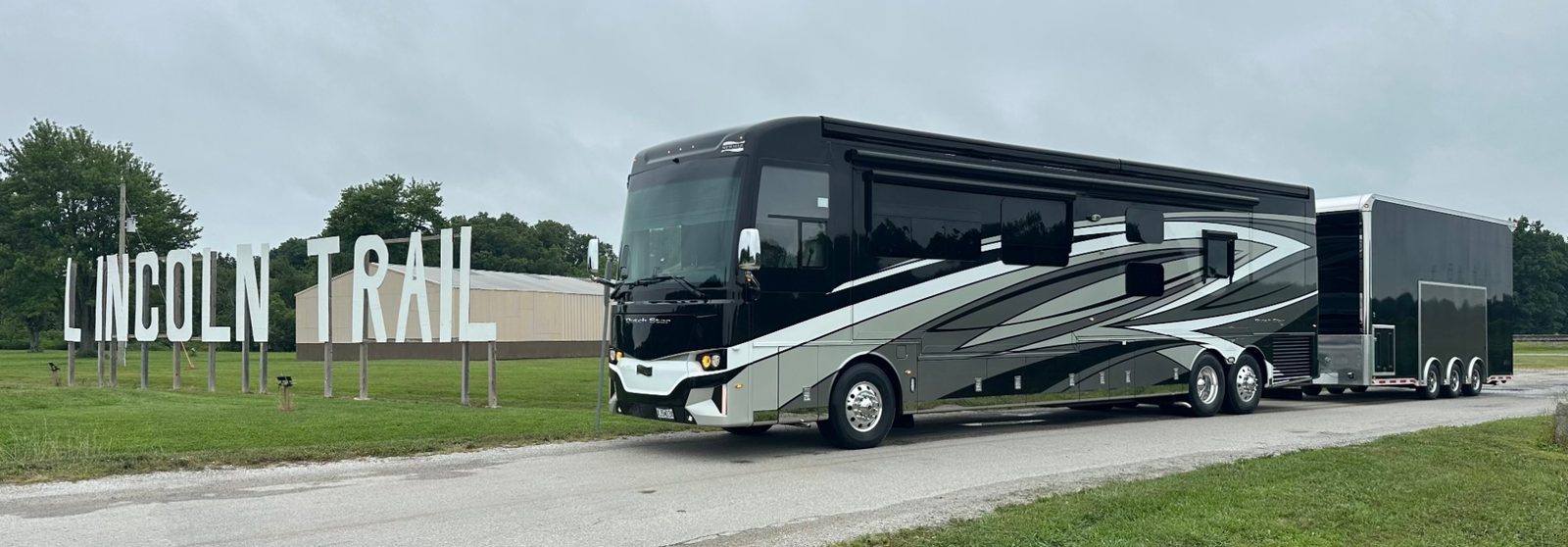 The LINC Racing Newmar Dutch Star coach and race trailer parked at the Lincoln Trail Motosports sign.